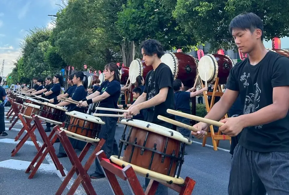 屋外イベントで和太鼓を演奏する若者チーム